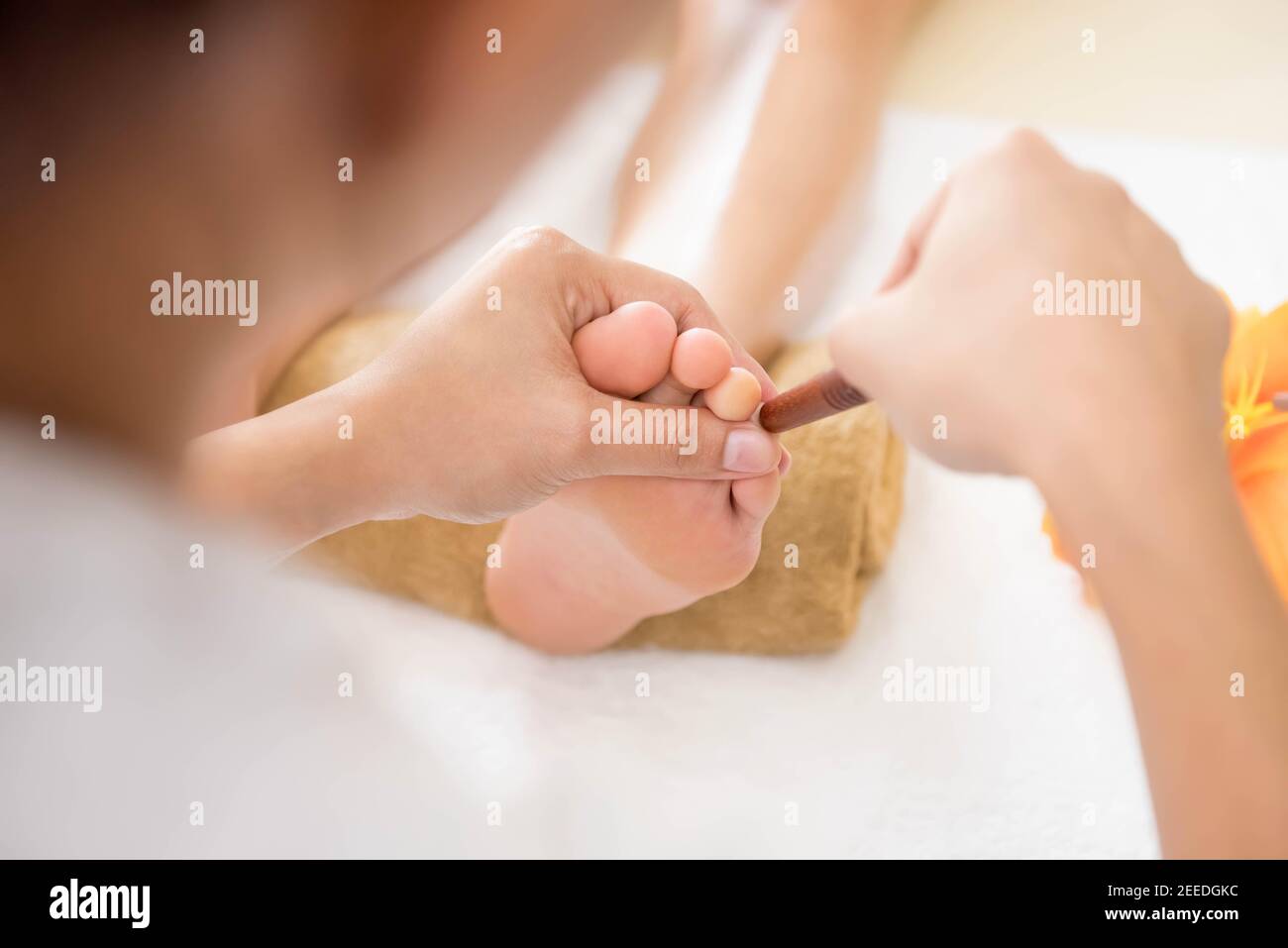 Un cliente che riceve un massaggio thailandese del piede con riflessologia e aromaterapia. Foto Stock