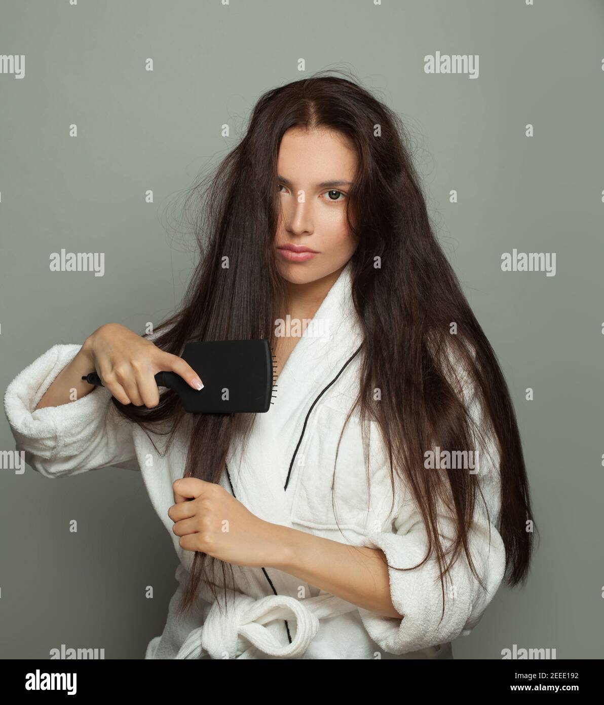 Bella donna con pettine su sfondo bianco, cura dei capelli e problema dei capelli Foto Stock