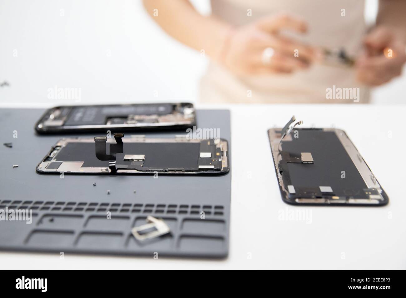 Processo di riparazione del chip del telefono cellulare, sostituzione della batteria e schermo rotto per il riciclaggio. Foto Stock