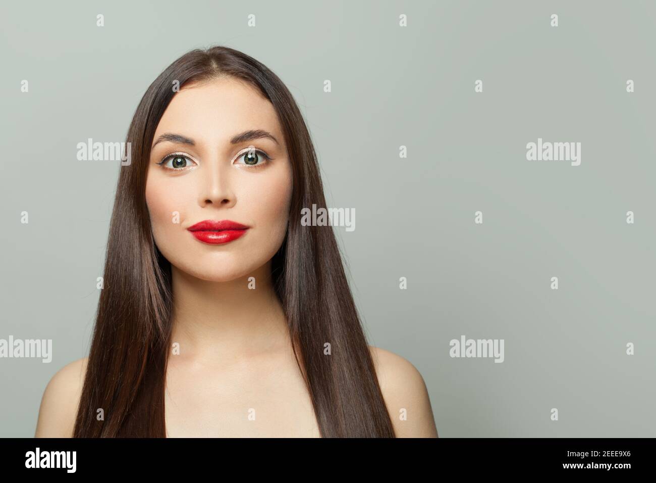 Giovane donna amichevole con pelle chiara e lungo sano diritto capelli su sfondo bianco Foto Stock