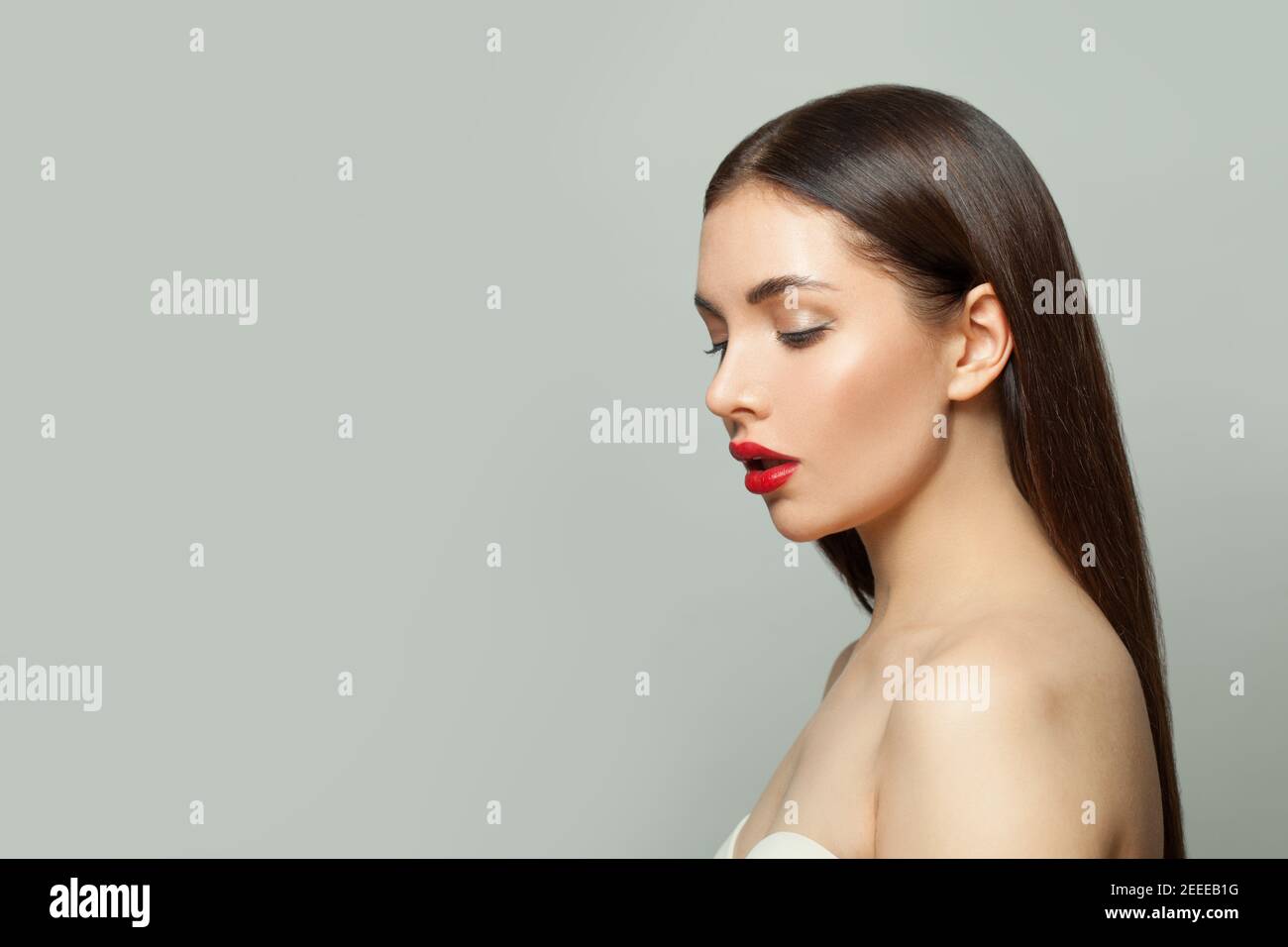 Donna sana con trucco e capelli lisci su sfondo bianco Foto Stock