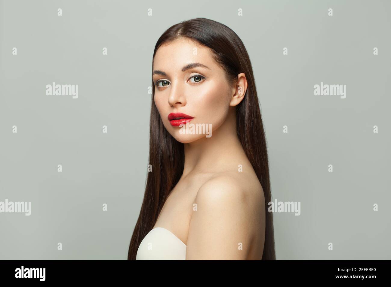 Celebrità donna brunette con pelle chiara e lungo sano diritto capelli su sfondo bianco Foto Stock