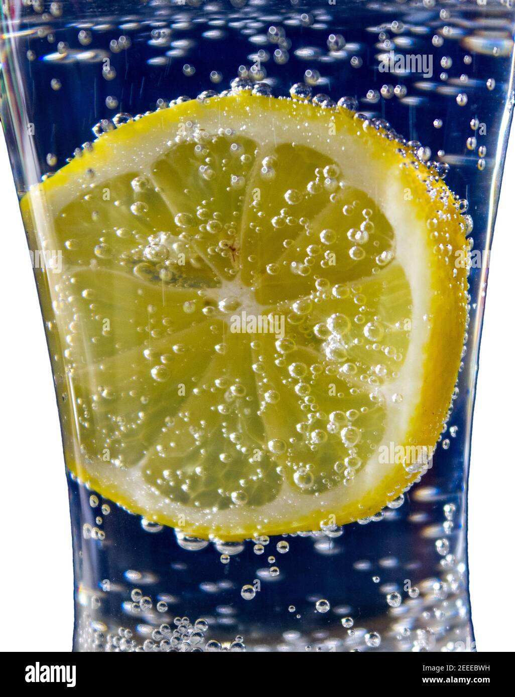 limone in acqua soda su sfondo blu Foto Stock