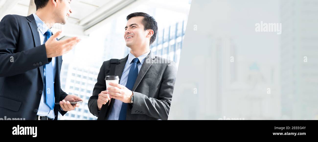 Uomini d'affari cordiali che parlano all'aperto mentre vanno a lavorare nel mattina - sfondo banner web panoramico con spazio di copia Foto Stock