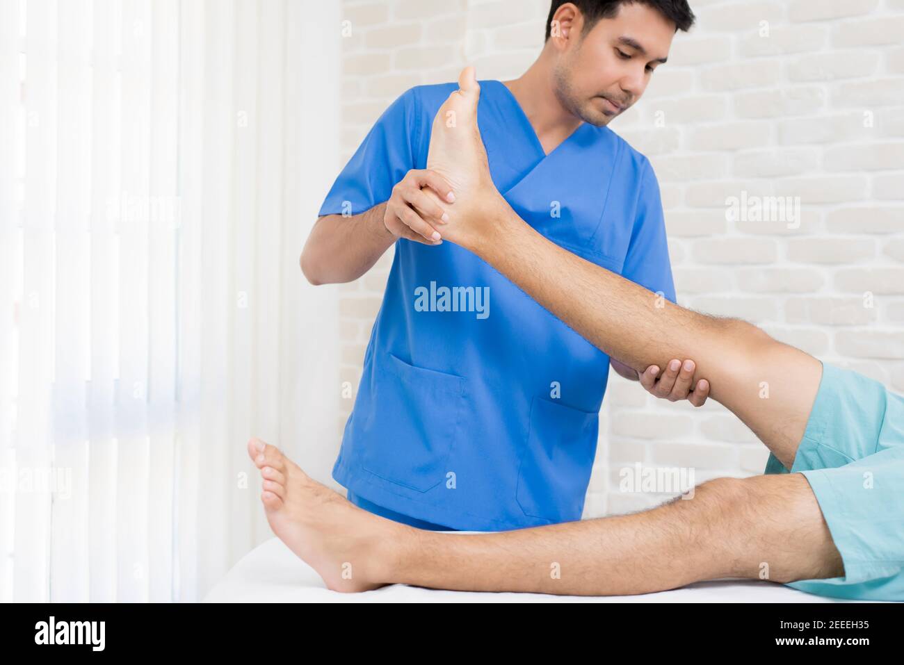 Terapeuta formazione esercizio di riabilitazione a paziente maschile in ospedale - concetto di terapia fisica Foto Stock