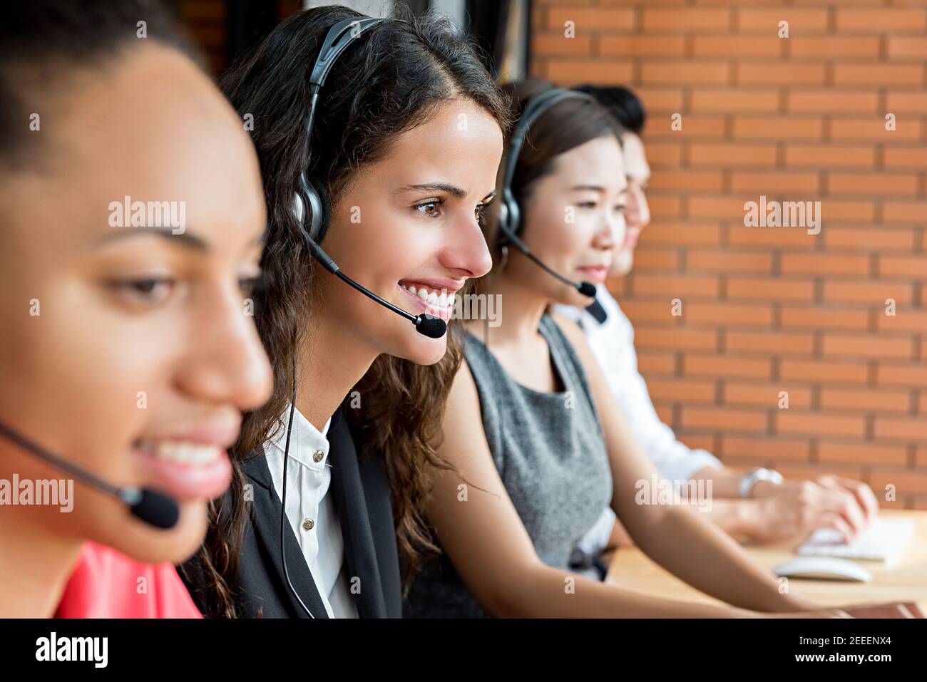 Sorridente team di agenti di telemarketing multietnico per il servizio clienti, concetto di lavoro del call center Foto Stock