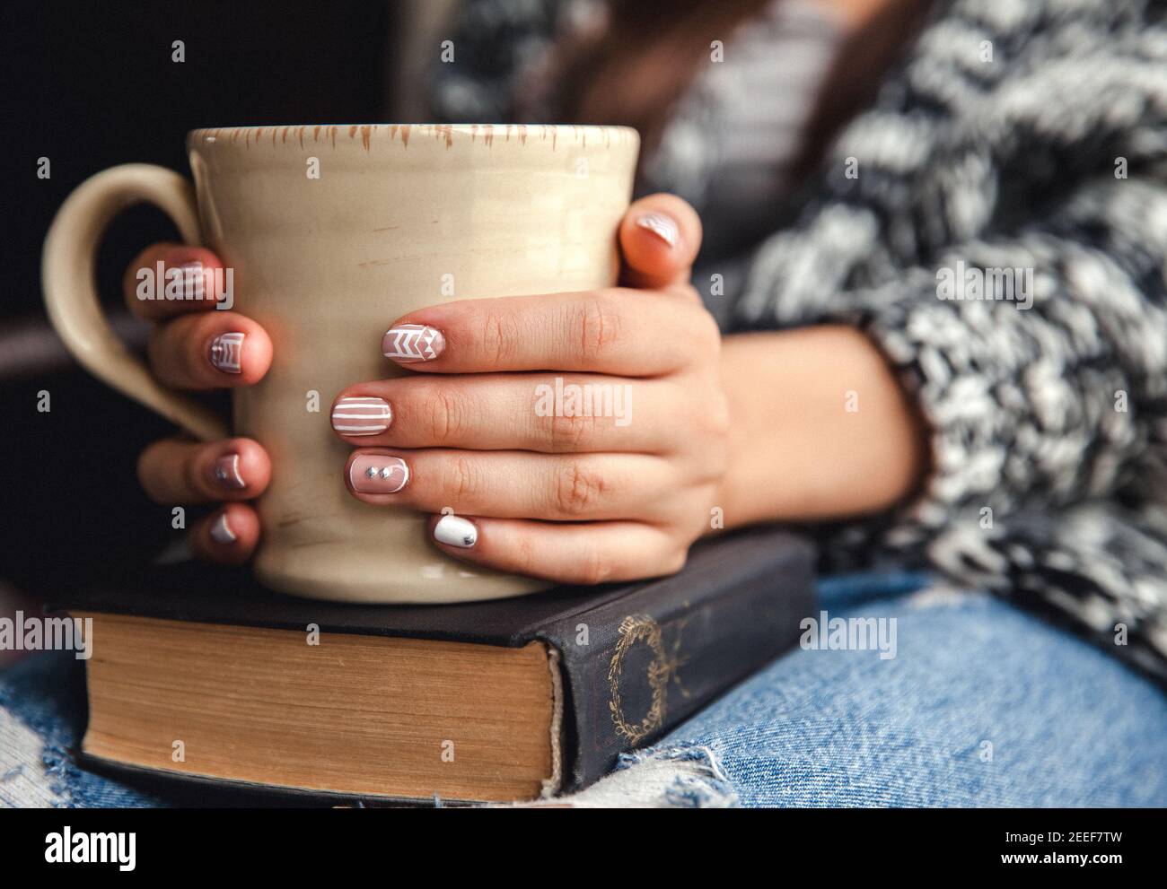 ragazza che ha una pausa con una tazza di caffè fresco dopo leggere libri o studiare Foto Stock