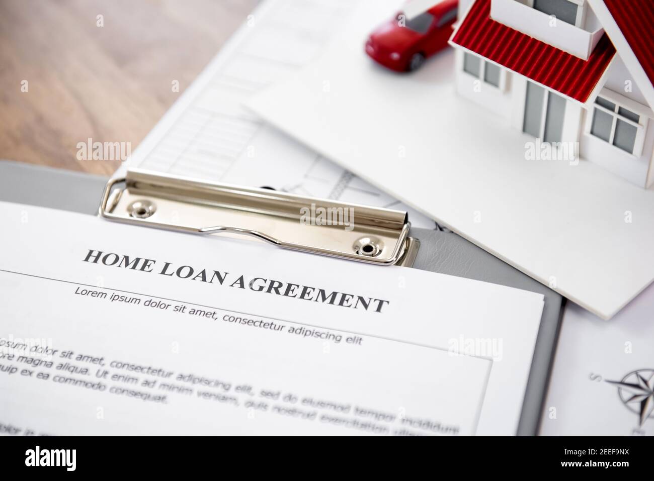 Carta di accordo di prestito domestico con il modello della casa sul tavolo - concetto finanziario estete reale Foto Stock
