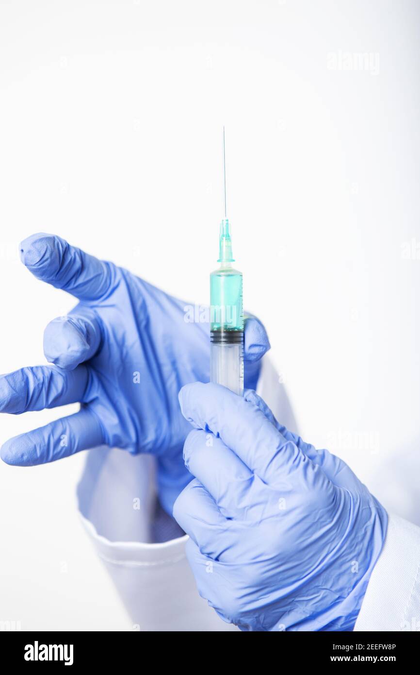 Primo piano delle mani del medico che prepara la siringa con il nuovo vaccino Foto Stock