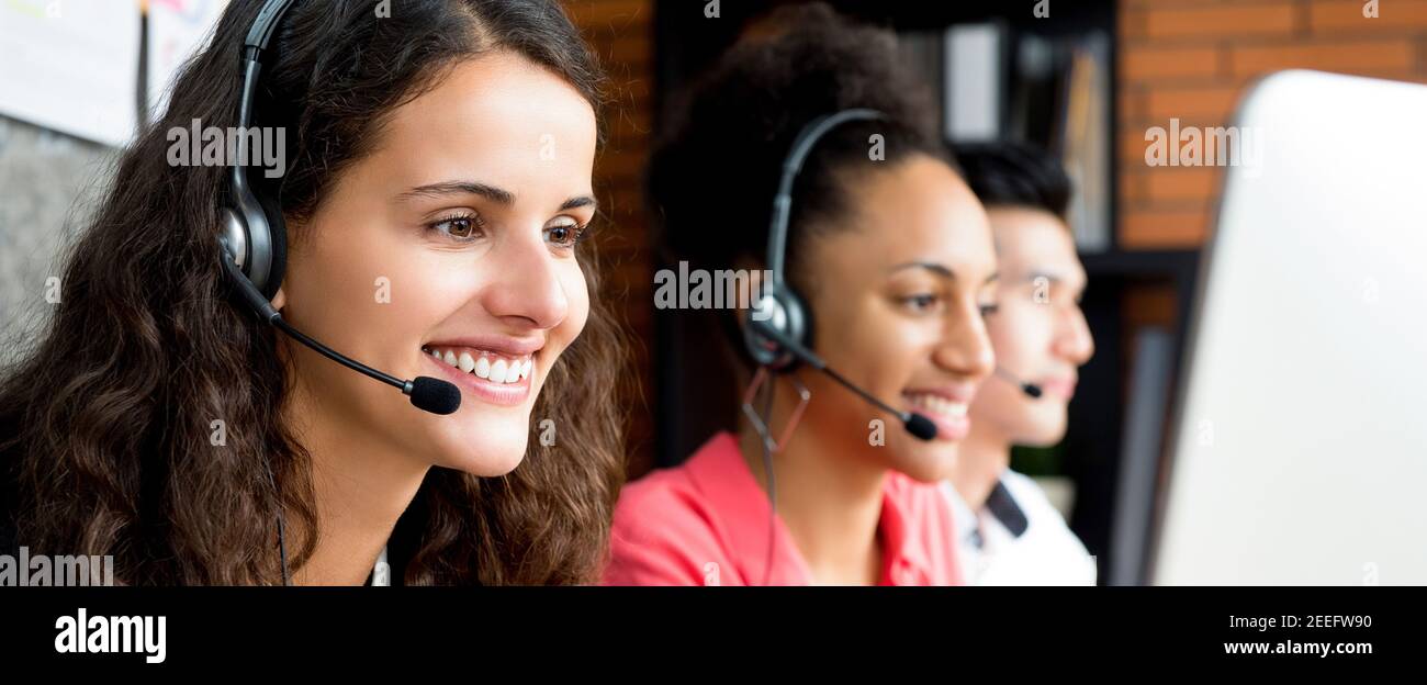 Gruppo di team di call center multietnici sorridenti - Panoramic web banner Foto Stock