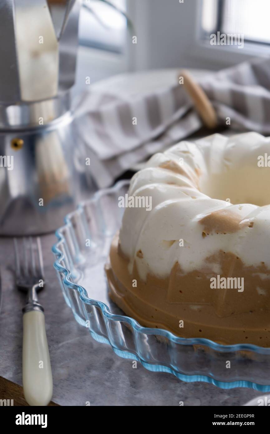 Pudding. Dessert di cioccolato al caffè al formaggio di cottage. Gelatina. Cupcake bianco sul tavolo. Il dolce budino è rotondo con un buco al centro. Vita morta su t Foto Stock