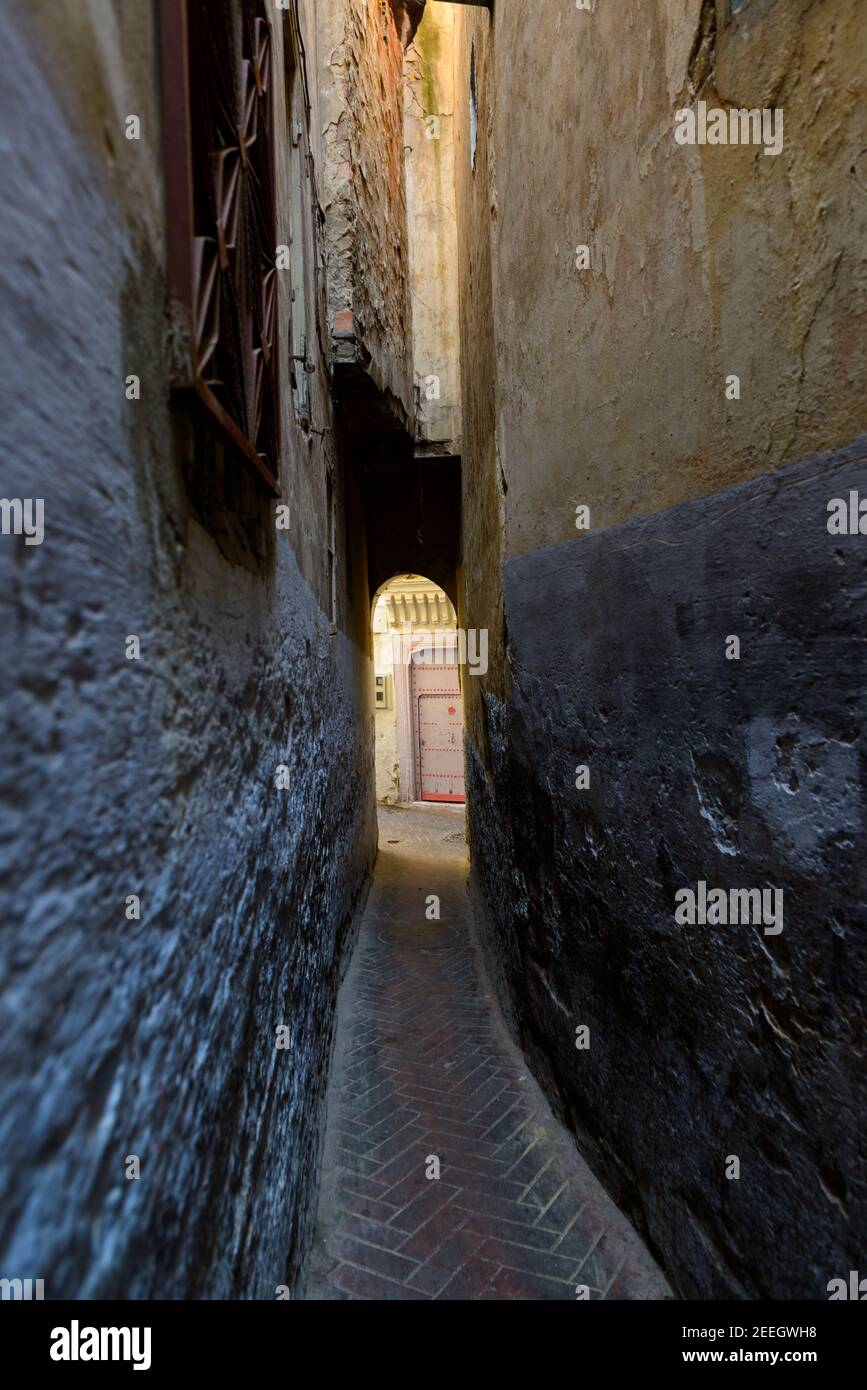 Vicolo stretto con porta rosa alla fine Tangeri, Marocco Foto Stock