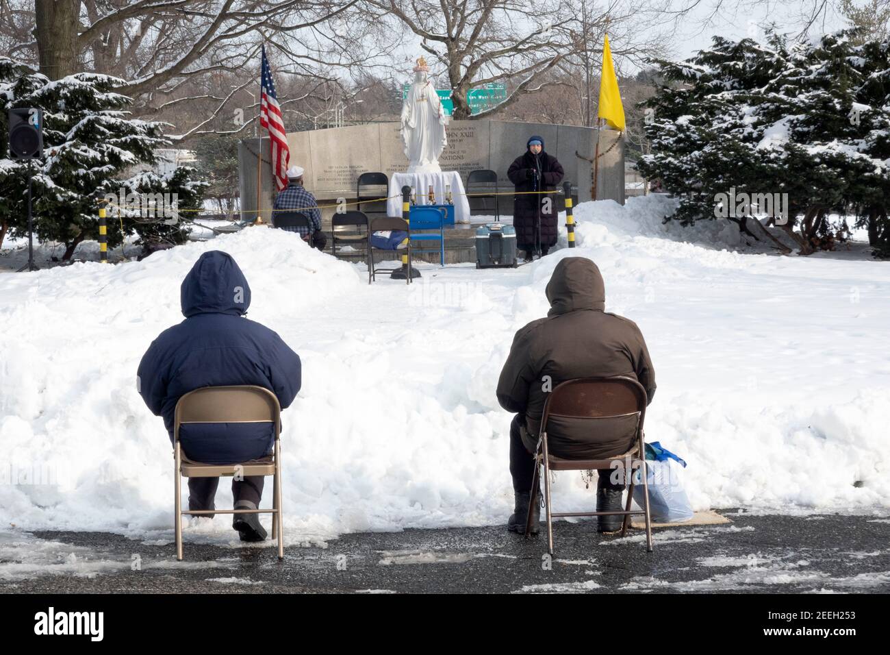 BAYSIDERS> Cristiani devoti assistono ad una messa invernale pomeridiana in un parco a Queens New York nel sito del 1964 Worlds Fair Vatican Pavilion. Foto Stock