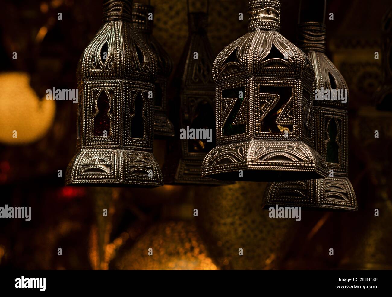 Lampada a motivi metallici marocchini con vetro color oro, rosso e blu nei souk di Marrakech. Lanterne ornamentali arabe. Foto Stock