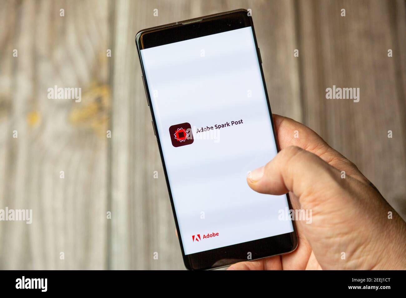 Un telefono cellulare o un telefono cellulare in attesa in un Mano con l'app Adobe SPARK aperta sullo schermo Foto Stock