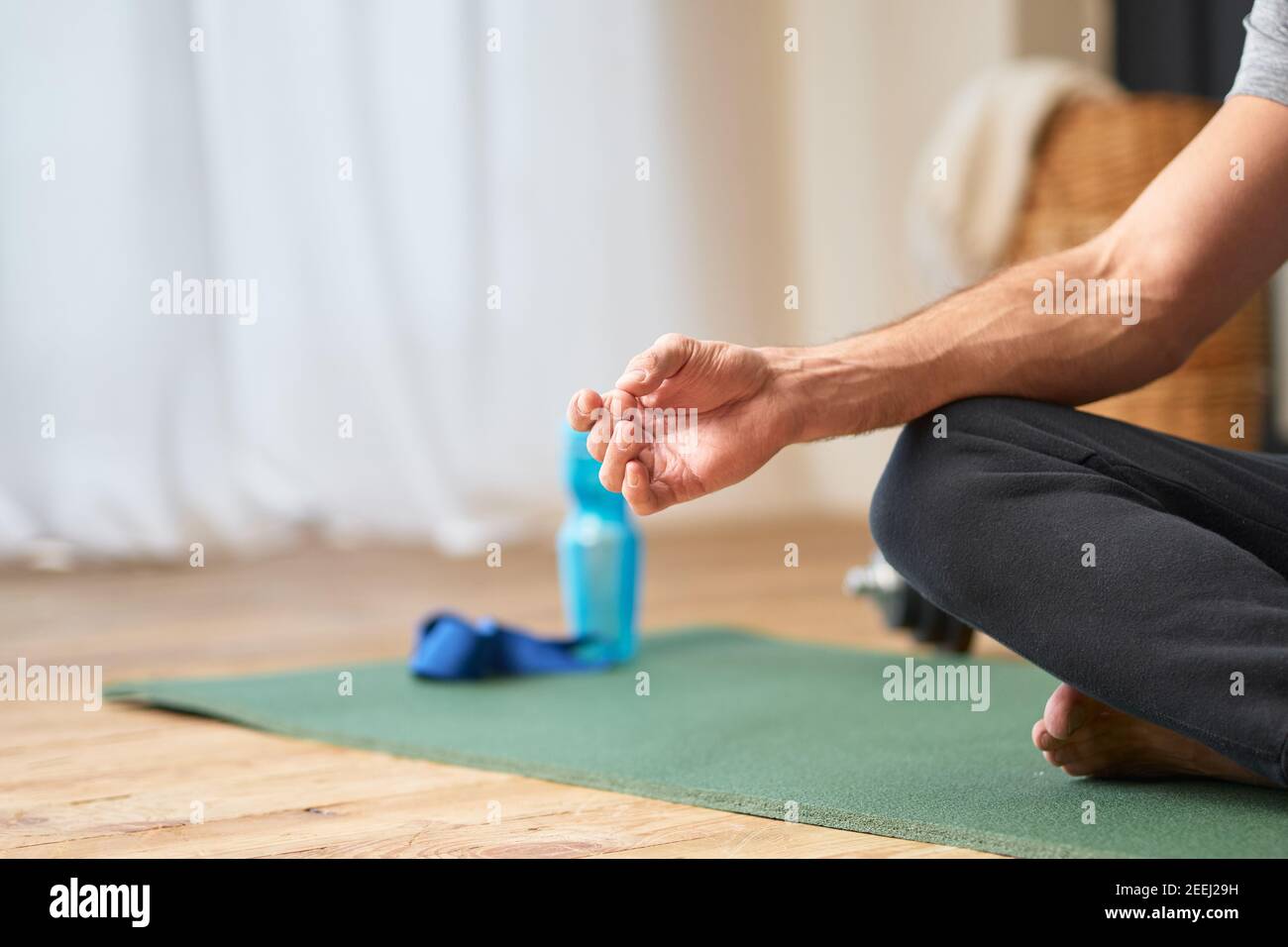 Primo piano del simbolo mudra gyan della mano maschile mentre l'uomo fare meditazione yoga esercizio a casa Foto Stock