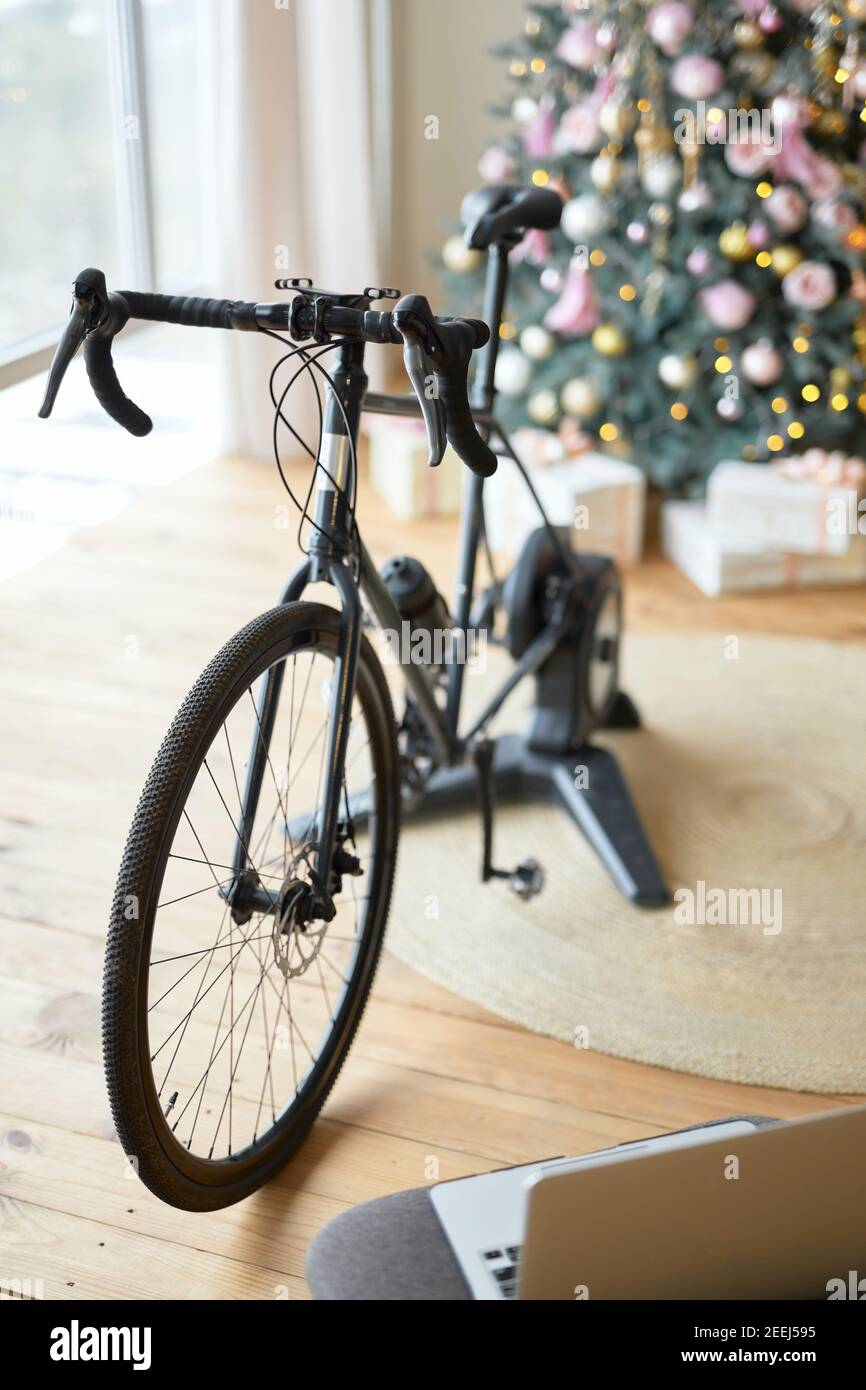 Cyclette o cyclette in appartamento con notebook e. Regali di Natale sotto l'albero Foto Stock