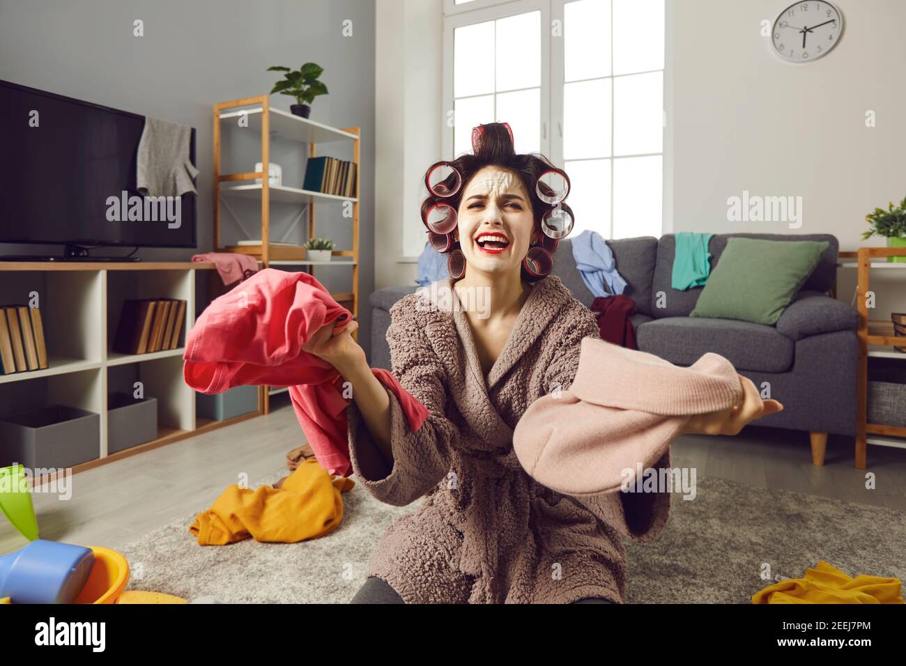 Stanca giovane casalinga ripulire la sua casa sudicia e lamentarsi circa il caos costante Foto Stock