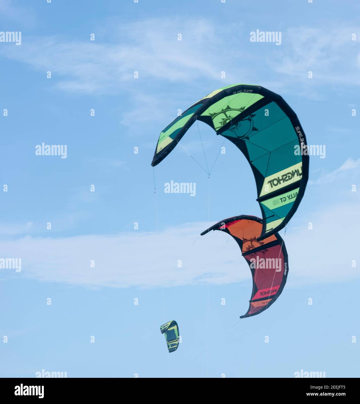 Le colorate vele per il kitesurf volano nel cielo nuvoloso. Mar dei Caraibi, Messico Foto Stock