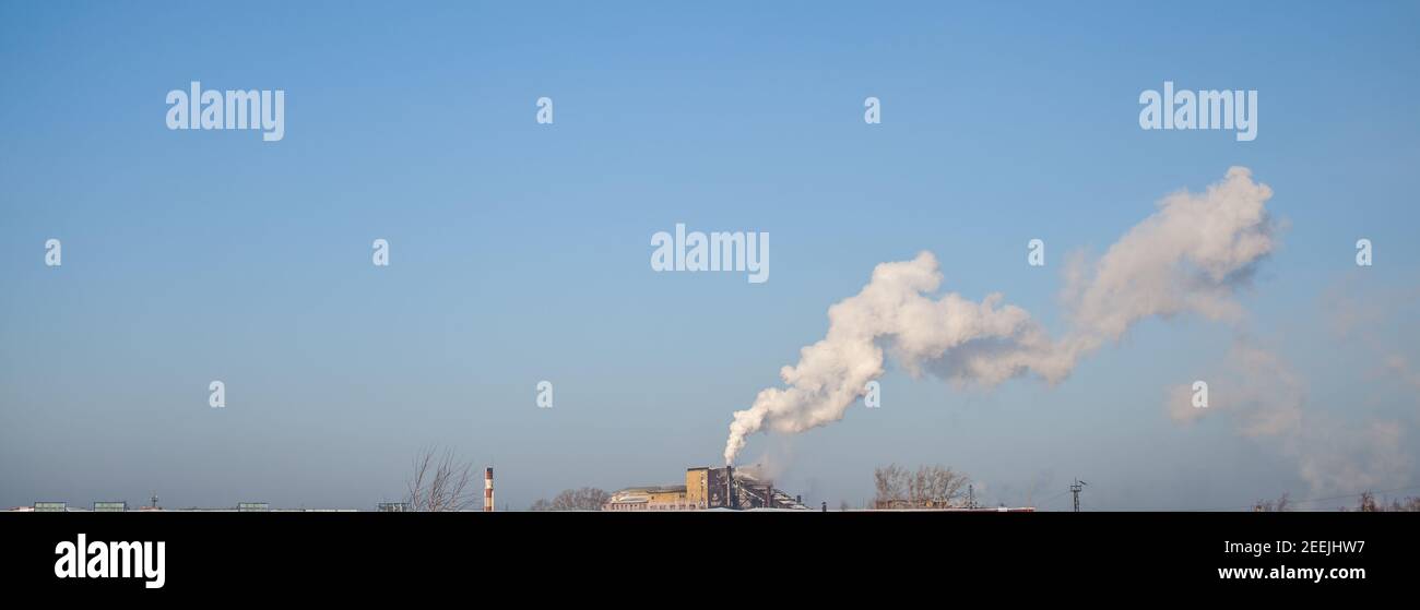 Fumo bianco spesso dal camino del locale caldaia. Fumo contro il cielo blu. Inquinamento atmosferico. Riscaldamento della città. Zona industriale. Foto Stock