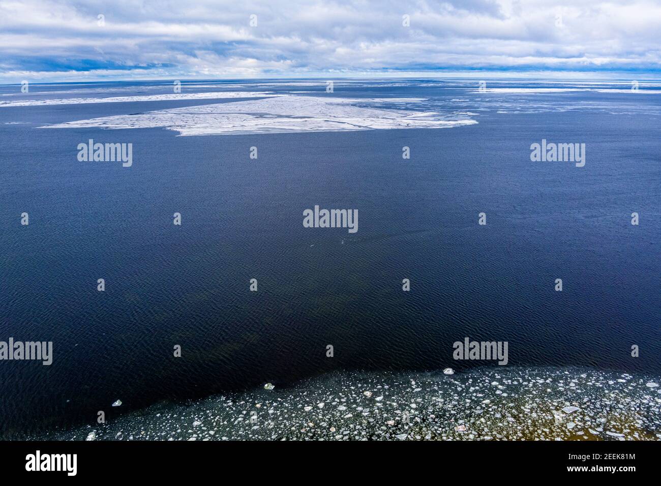 Blocchi di ghiaccio che si sgocciolano intorno in un'acqua di mare calma che genera i modelli aerei interessanti. Ripresa dal drone Foto Stock