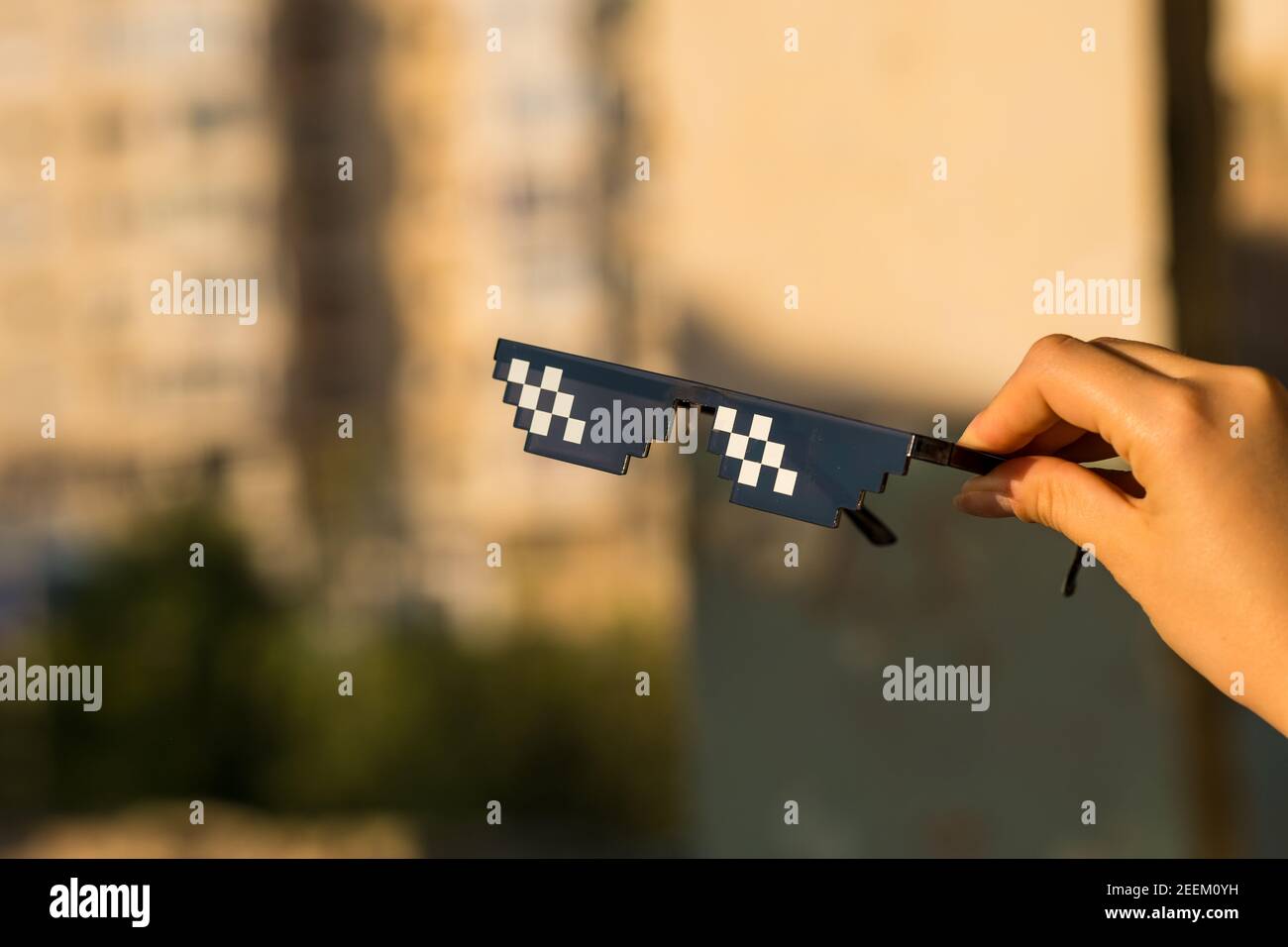 Gli occhiali da sole THUG Life sparano in una zona urbana in una giornata di sole. Messa a fuoco selettiva Foto Stock