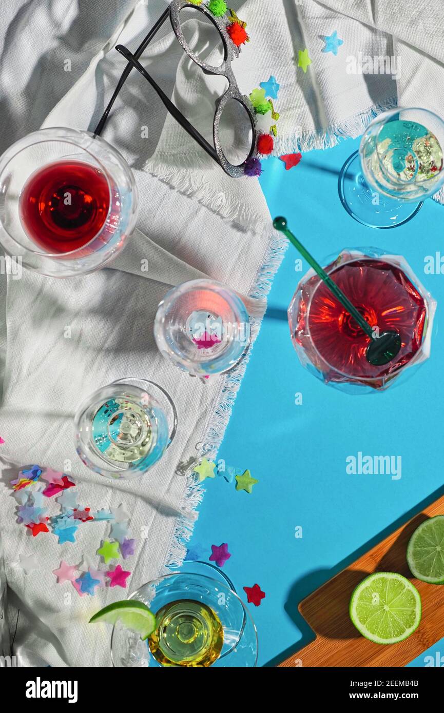 immagine di bicchieri di liquore dopo una celebrazione su bianco sbriciolato tovaglia e sfondo blu con resti Foto Stock