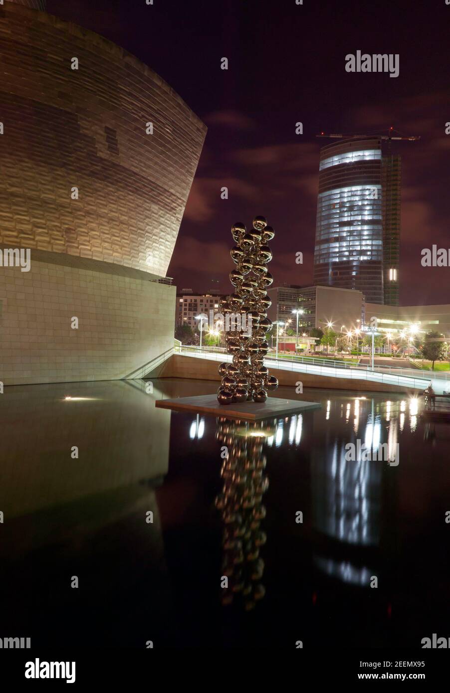 Vista notturna della scultura di Anish Kapoor, dell'albero alto e dell'occhio, fuori dal Museo Guggenheim, Bilbao Foto Stock