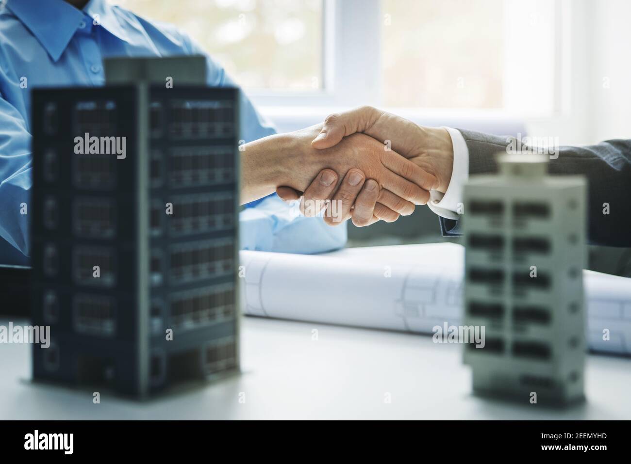 sviluppo del bene immobile - handshake degli uomini d'affari dopo accordo riuscito di progetto di costruzione di edifici commerciali e di appartamenti Foto Stock