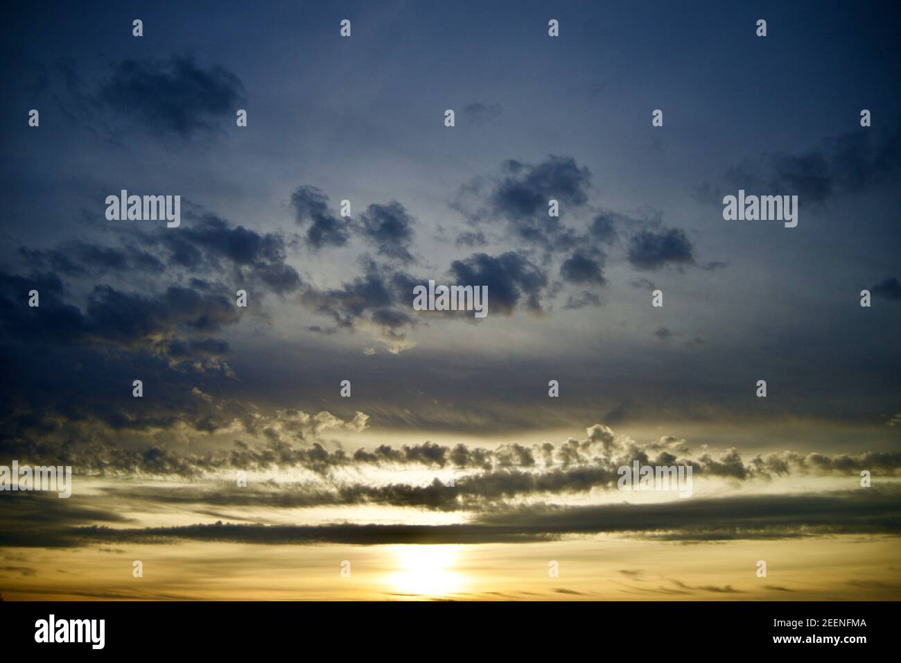 Bellissimo tramonto con nuvole blu, grigie e arancioni Foto Stock