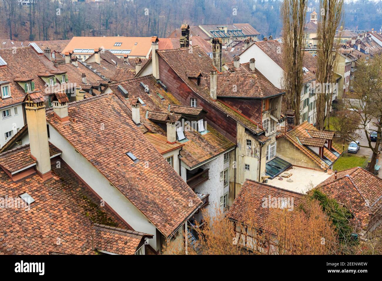 Tetti rosso-marrone di belle città fatte di piastrelle naturali. La vista dall'alto. In lontananza, l'orizzonte del cielo blu. Foto Stock