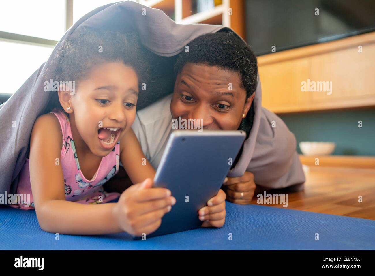 Padre e figlia usano il tablet digitale a casa. Foto Stock