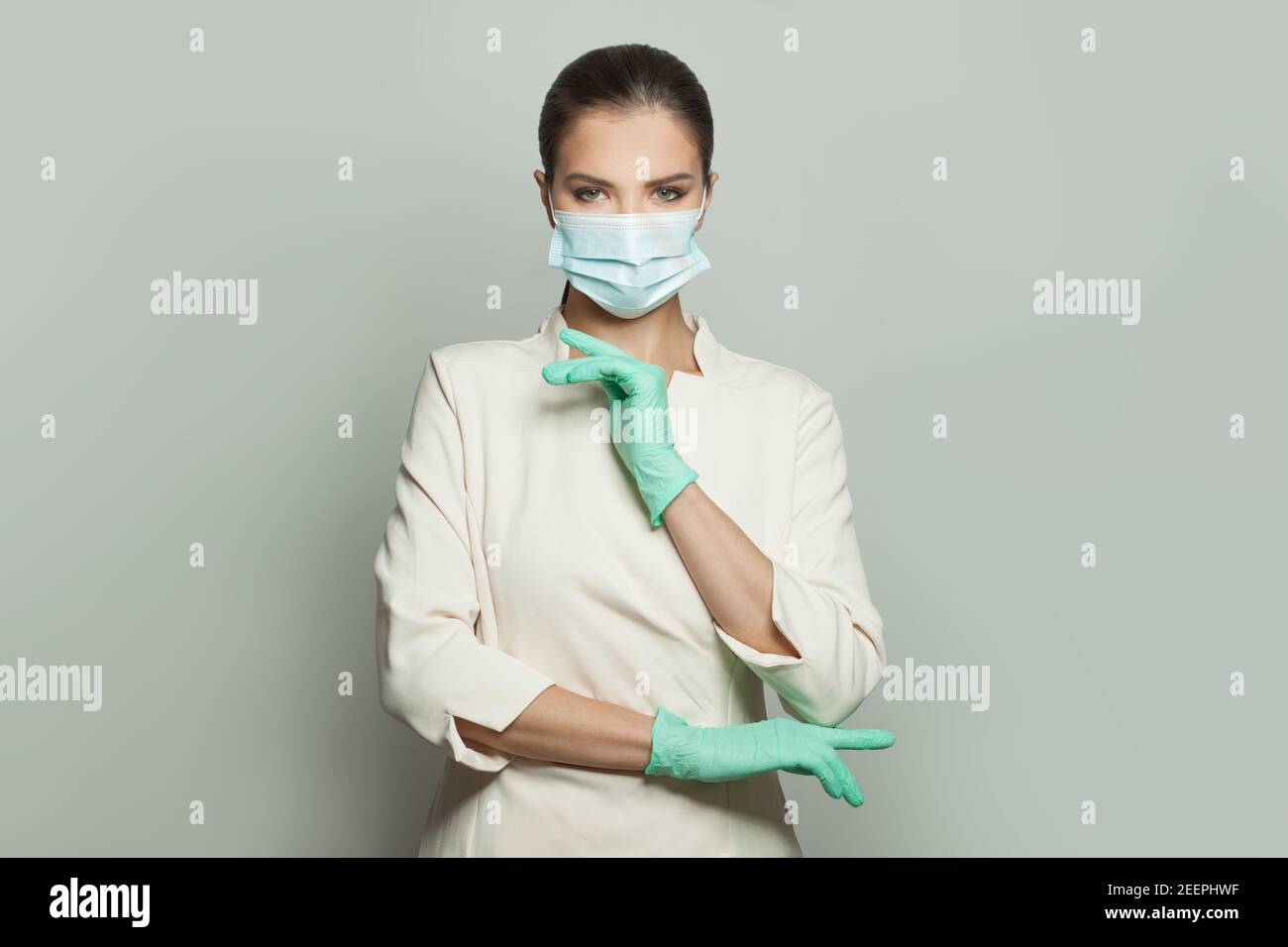 Medico donna in maschera medica su sfondo bianco. Medicina, cosmetologia e concetto di vaccinazione Foto Stock