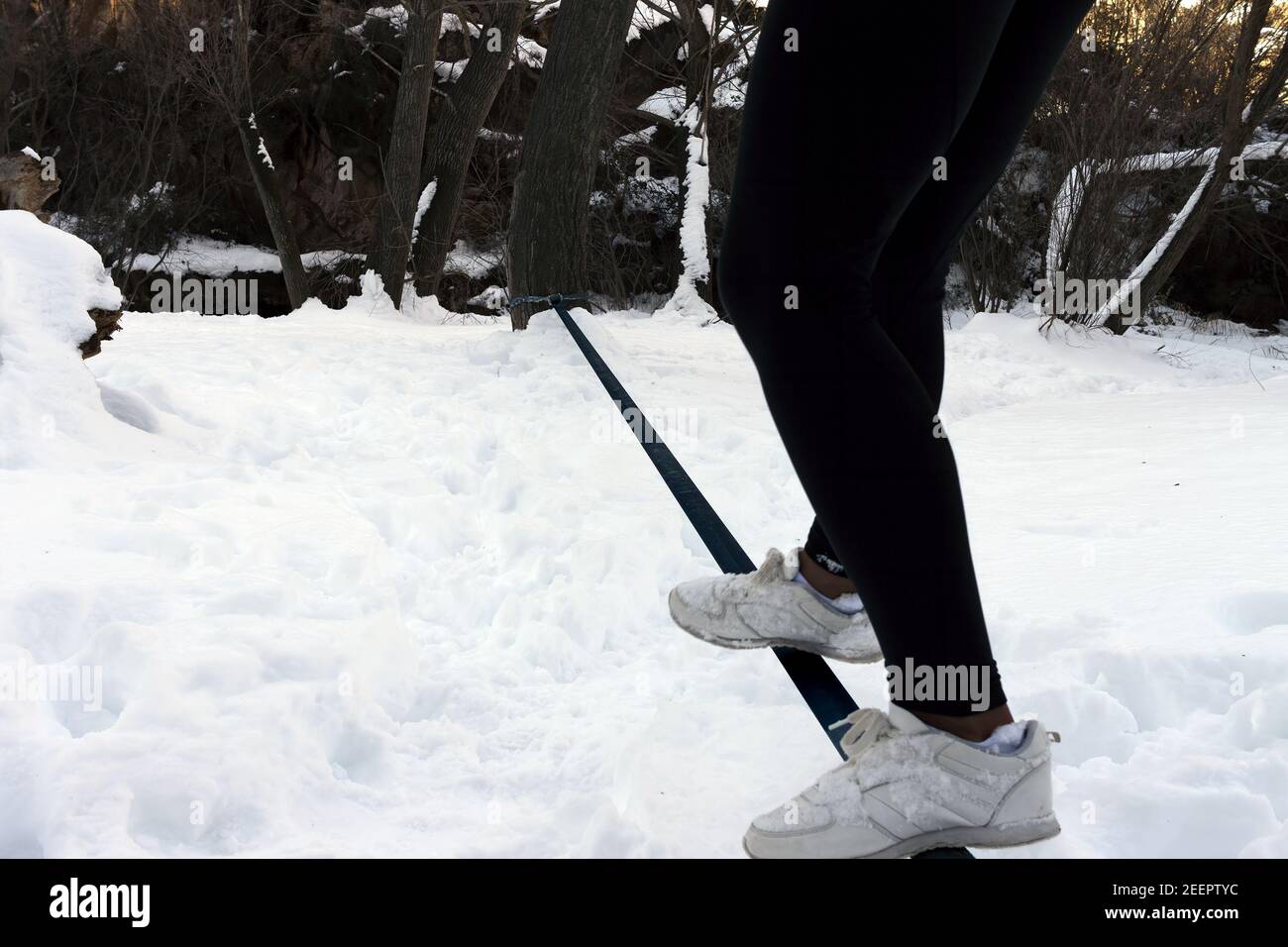 Un giovane adolescente equilibra un tightrope nella neve Foto Stock