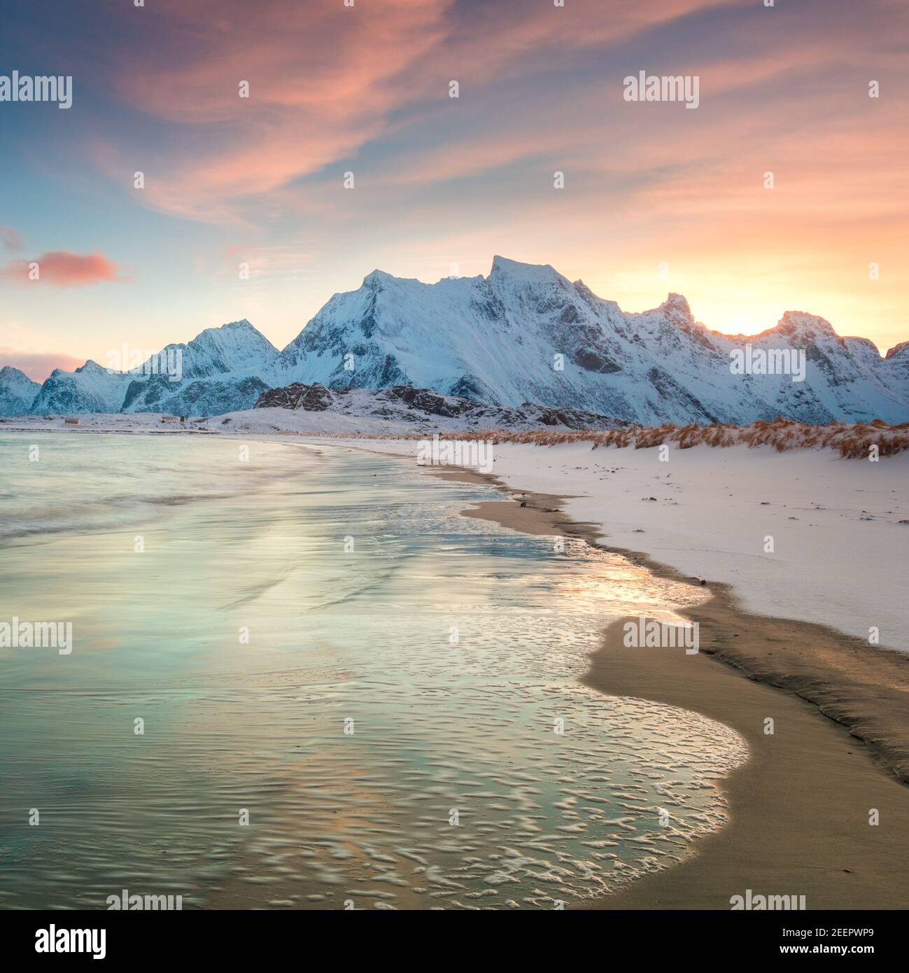 Incredibile mattina invernale sul mare e sulle montagne, colorata alba settentrionale e luce solare nelle nuvole rosa. Isole Lofoten, Norvegia, Europa Foto Stock