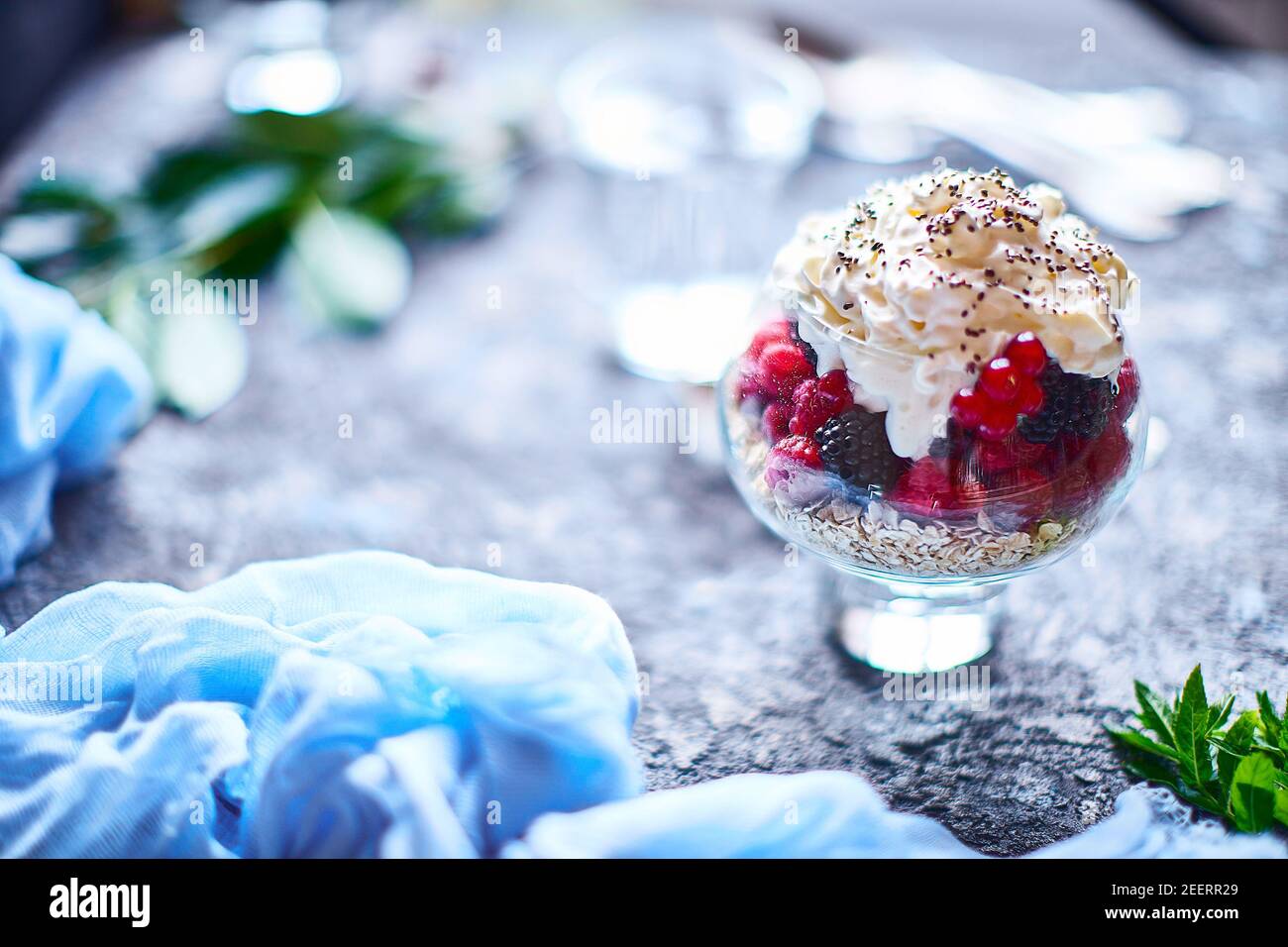 Idee di ricetta per la colazione di dieta estiva, dessert sano del mattino in vasi porzionati con frutti di bosco estivi - lampone, ciliegie, mora. Su fondo di pietra. Foto Stock