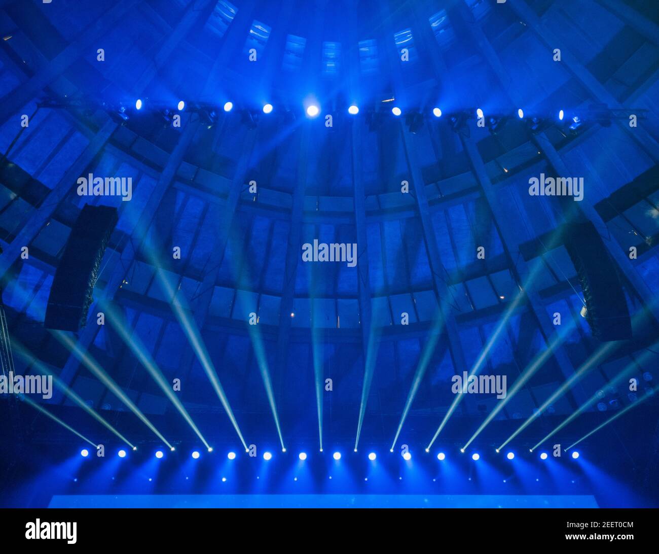 Ricerca al soffitto nella sala conferenze con luci blu sopra schermo Foto Stock