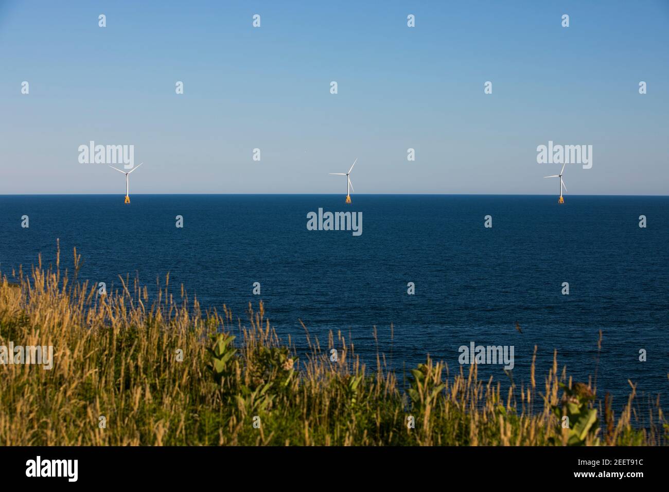 Le turbine eoliche si ergono sulle rive di Block Island, Rhode Island, USA, in una splendida giornata di sole. Foto Stock