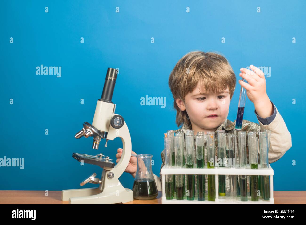 Ricerca e istruzione a scuola. Bambino piccolo che fa esperimenti di scienza. Foto Stock