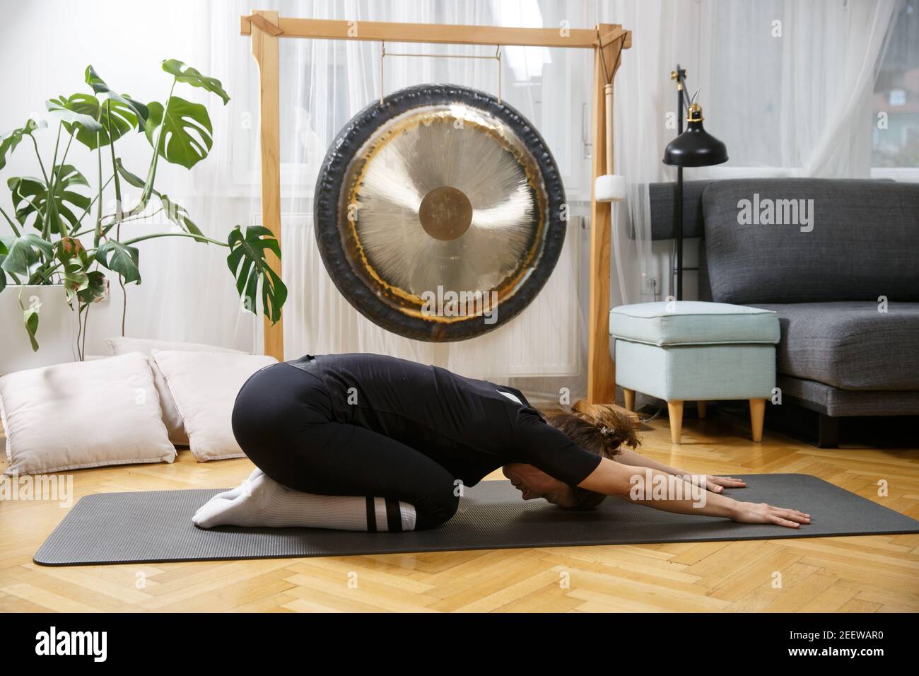 Fit donna attiva stretching, facendo pilates e yoga fitness esercizio in camera a casa. Fitness domestico. Stile di vita sano e sportivo. Foto Stock