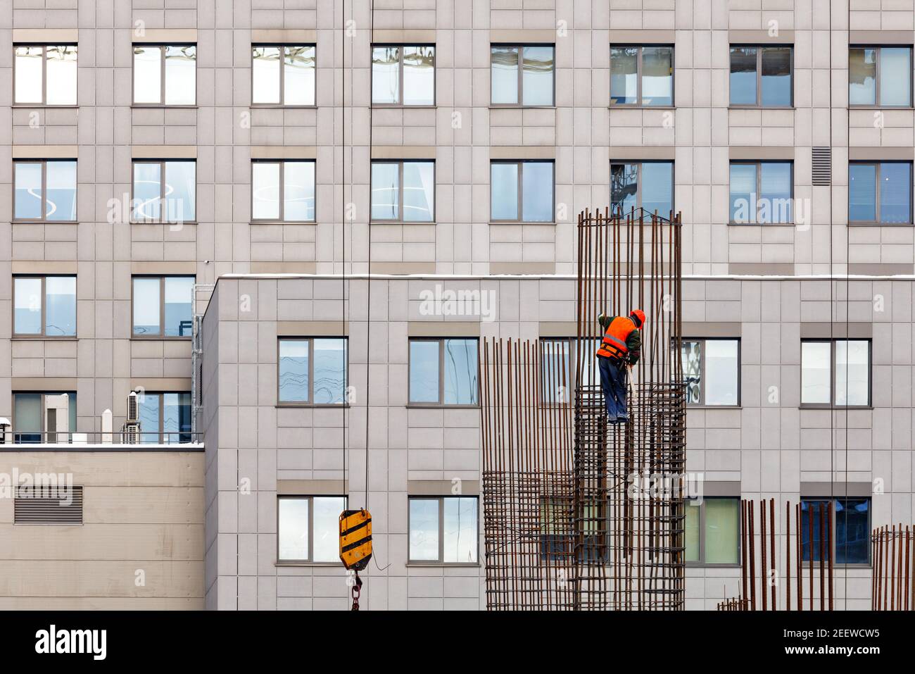 Un lavoratore effettua l'installazione di un telaio metallico da aste di acciaio in un cantiere. Foto Stock