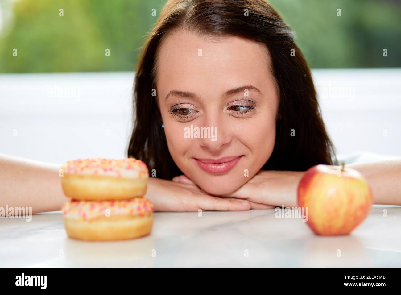 Ragazza rendendo la scelta tra un sano/alimenti dannosi per la salute Foto Stock