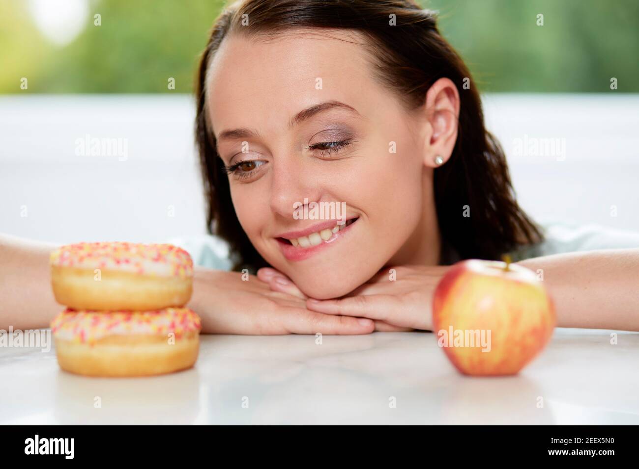 Ragazza rendendo la scelta tra un sano/alimenti dannosi per la salute Foto Stock