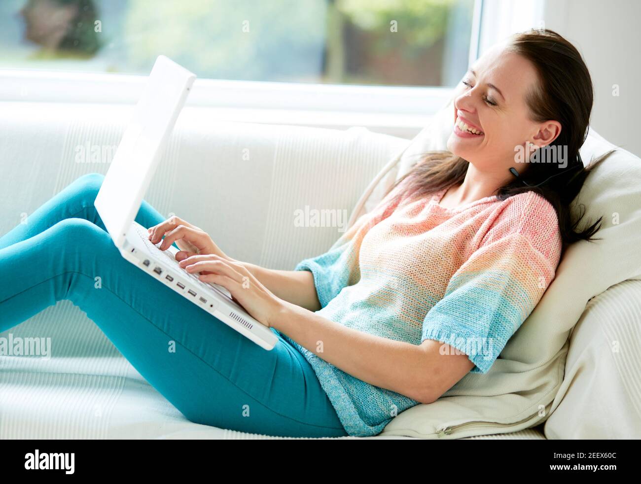 Donna che sorride con il laptop Foto Stock