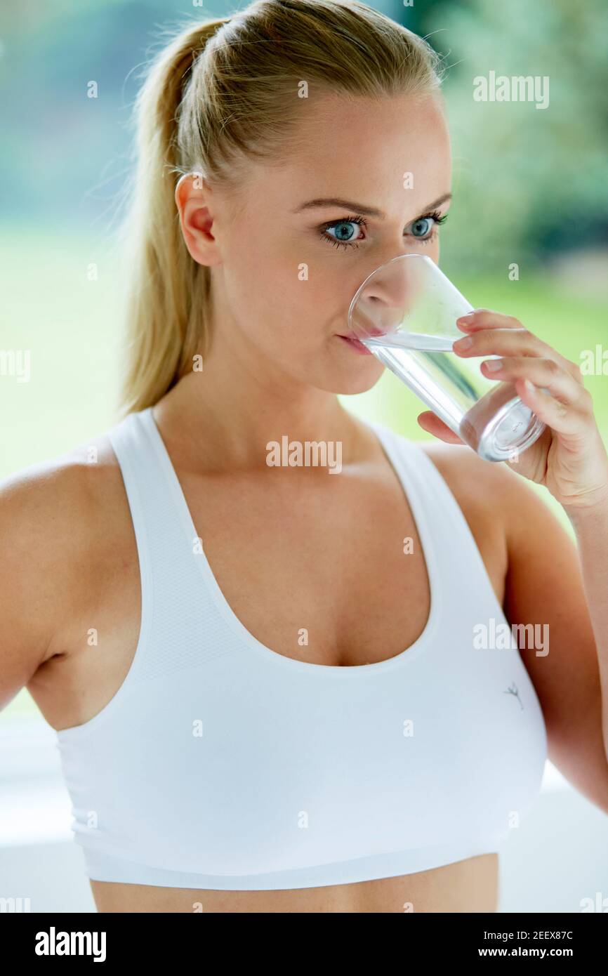 Donna di bere un bicchiere di acqua Foto Stock
