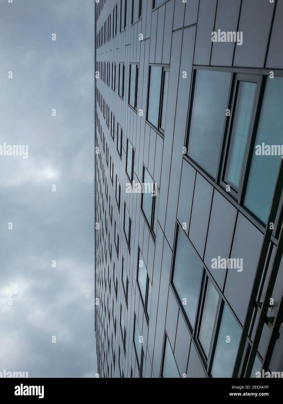 Cerca le nuvole che si riflettono nell'edificio aziendale Foto Stock