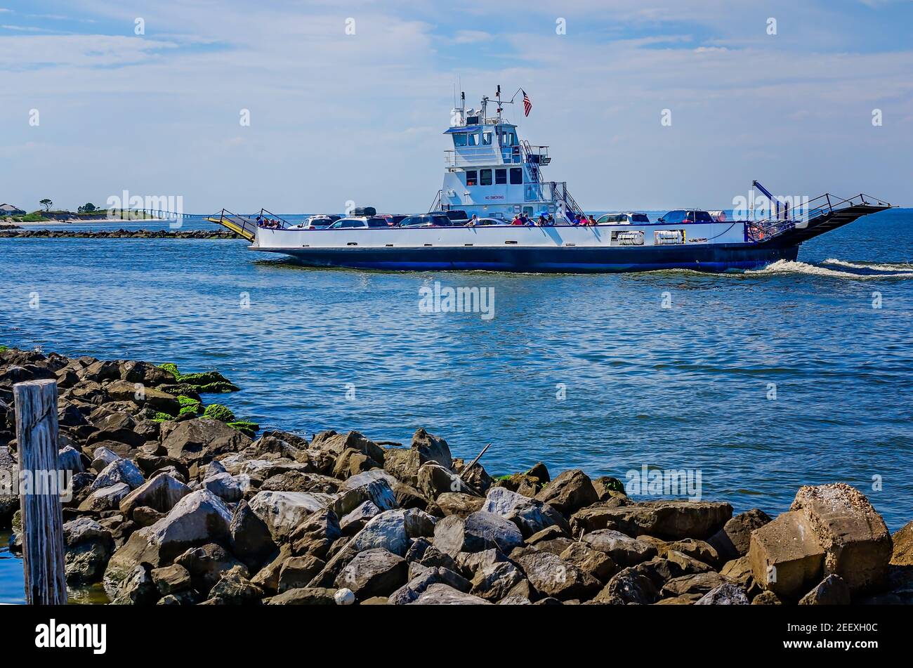 Il Mobile Bay Ferry passa davanti a un molo di roccia e porta i turisti a Gulf Shores, 2 agosto 2017, a Dauphin Island, Alabama. Foto Stock