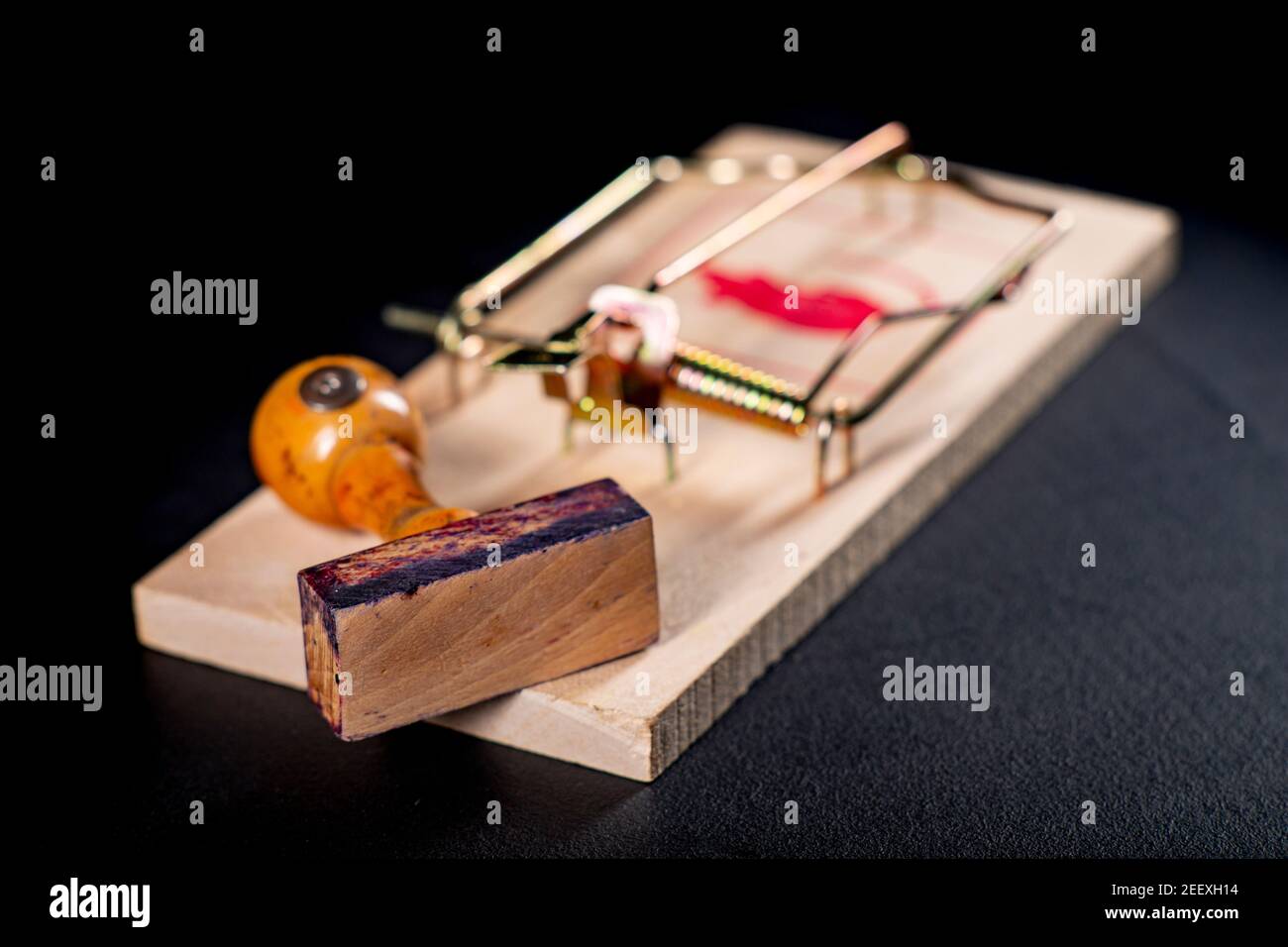 Un mousetrap con un timbro di ufficio in legno. Una trappola per i funzionari sotto forma di decisioni emesse. Sfondo scuro. Foto Stock