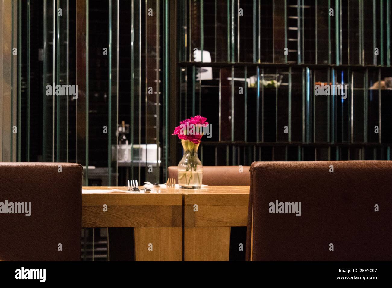 un tavolo in un ristorante con una caraffa con rose Foto Stock