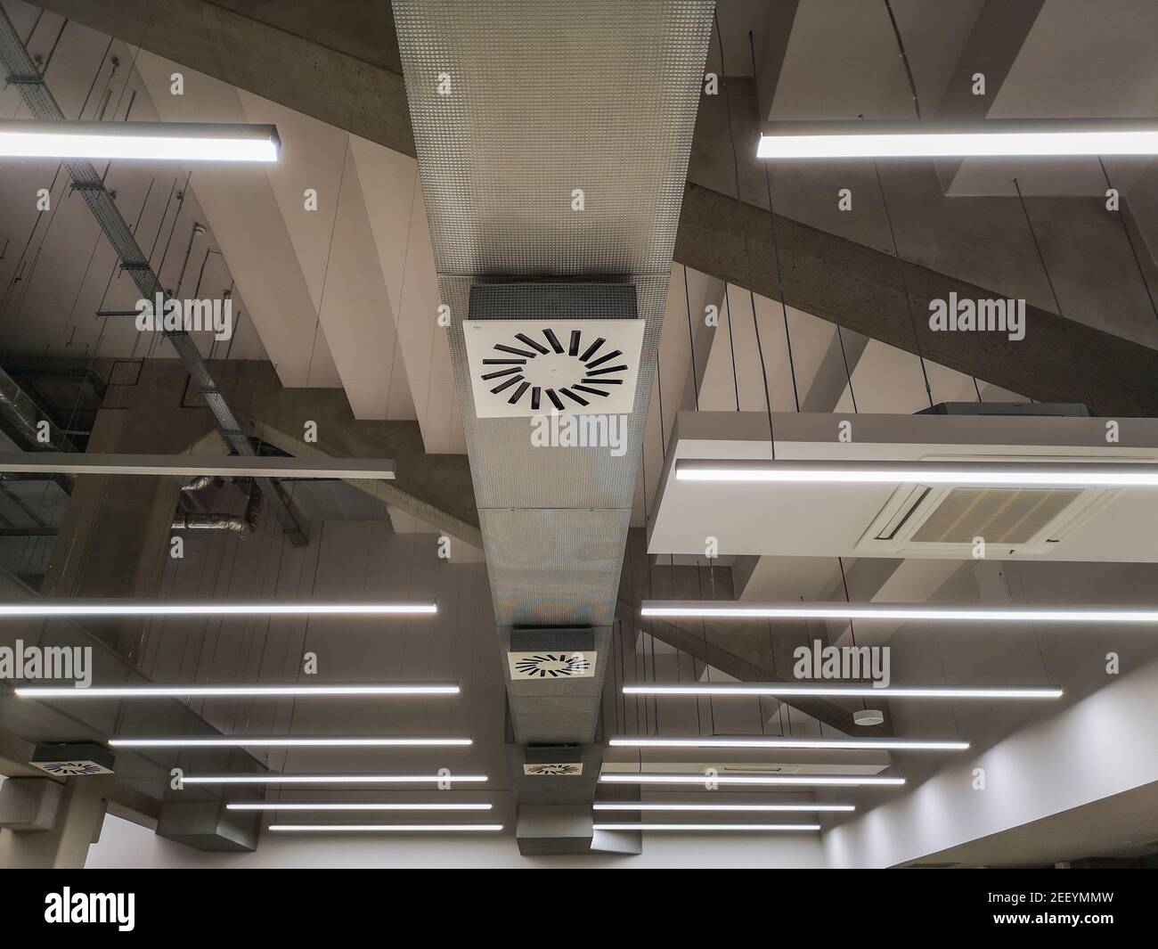 Lampade incandescenti appese sotto il soffitto e condotti di ventilazione Foto Stock